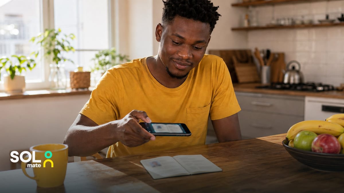 Opening a bank account online in South Africa — a man photographing his identity document with his phone at the kitchen table